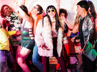 Image is of a group of people dancing at a party.