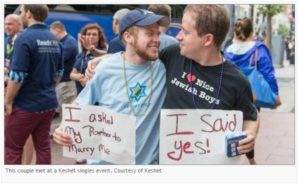 Image shows two gay Jews together. One of them is holding a sign that says "I asked my partner to marry me." The older holds a sign that reads, "I said yes!"