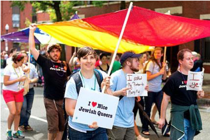 Image of members of Keshet marching in a Pride Parade. One person holds a sign that reads "I heart nice Jewish queers."
