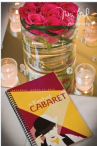 Image of a program for Keshet Cabaret, alongside a bowl of pink roses and candles.