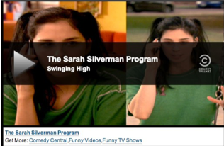 Image of a screen showing Sarah Silverman in a green shirt with the words: "The Sarah Silverman Program: Swinging High" on it.