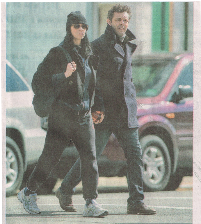 Image of a newspaper photo showing Sarah Silverman and Michael Sheen walking across a road hand in hand.