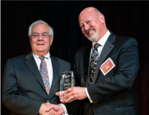 Image of Barney Frank and another man standing and holding an award.