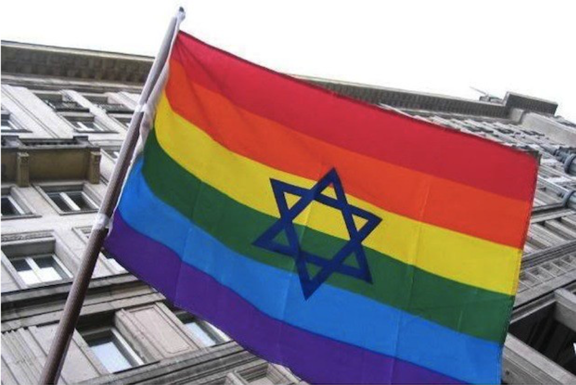 Image of a rainbow LGBTQ flag with a Star of David on it flying outside a building.