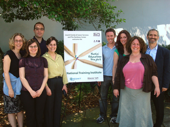 A group of people standing outside next to a sign.