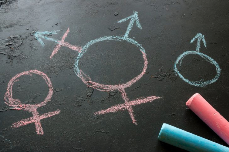 Image of chalk drawings of the male, female, and androgynous symbols in pink and blue.