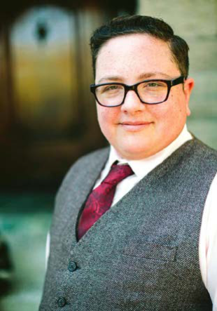 Image of Rabbi Elliot Kukla wearing a tie and and vest, standing outside.