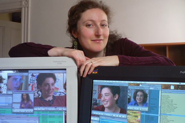 Image of "Hineini" filmmaker and director Irena Feyngold posing with two computers.
