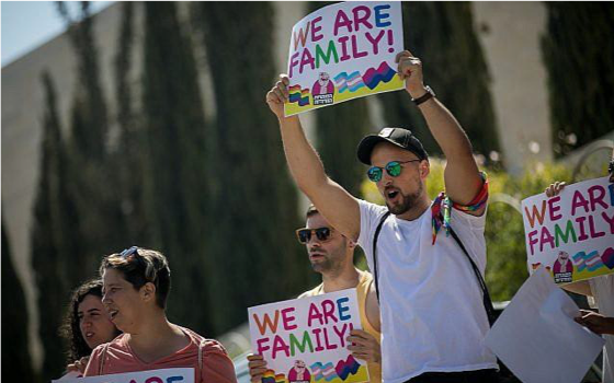 Image of several people holding up signs that read "We are family!"
