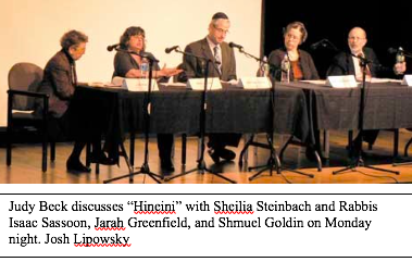 Image of a panel of people sitting in front of a table and microphones.