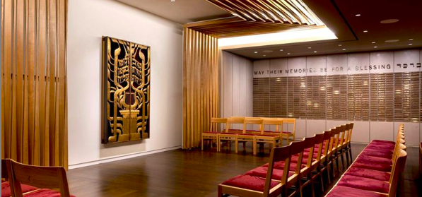 Image of a large room with red chairs, hardwood floors, and a black and gold painting on the wall.