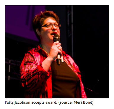 Image of Patty Jacobson speaking into a microphone.