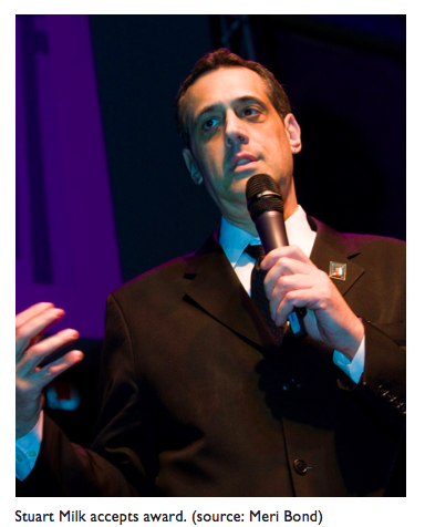 Image of Stuart Milk speaking into a microphone.