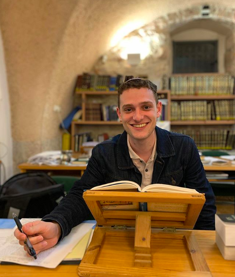 Bennett Decker sitting at a desk with an open book