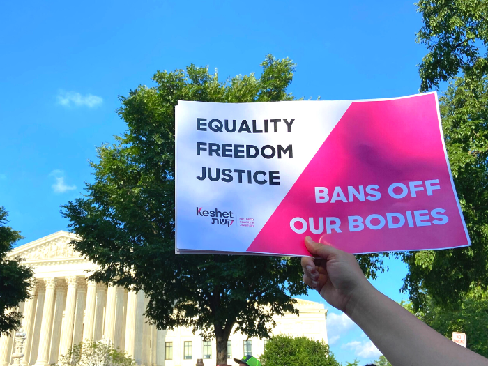 A sign that reads "Equality. Freedom. Justice. Bans off our bodies." held up in front of the Supreme Court