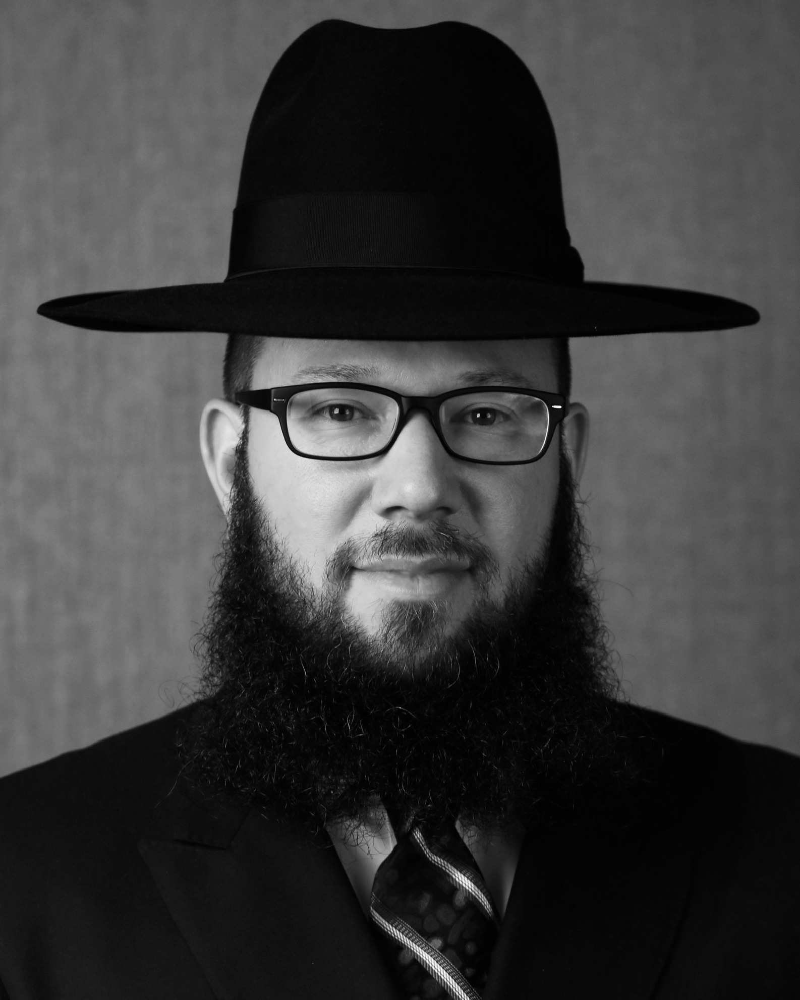 A rabbi with glasses, a beard, and a hat