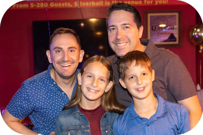 An image of two dads with their two children