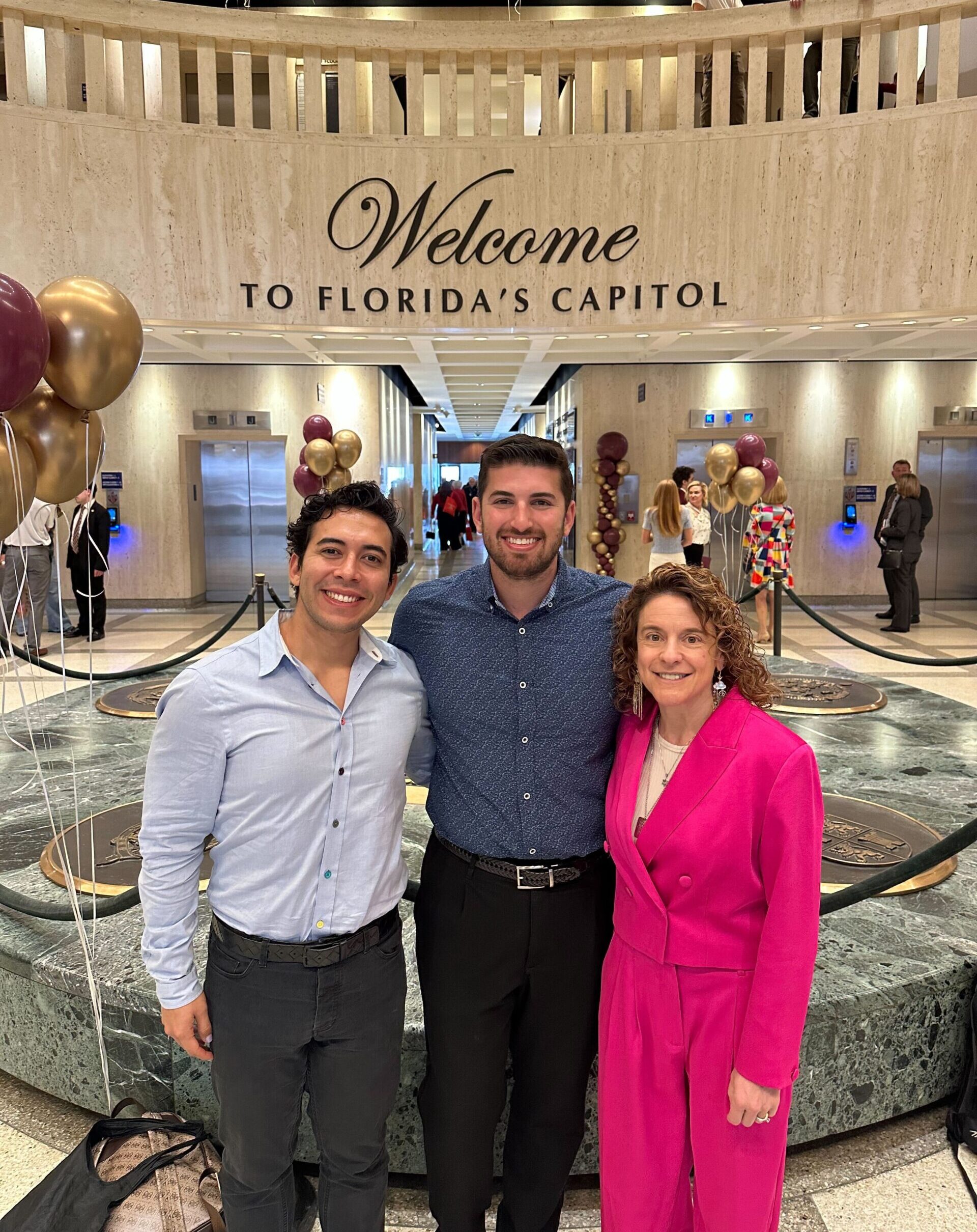 Jon Cohen, Tracey Lagbold, and David Weitzman stand in the Florida capitol