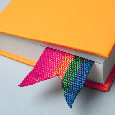 book with rainbow bookmark signifying lgbtq belonging 